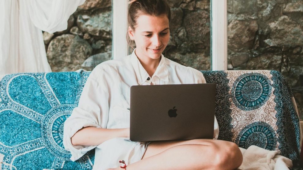 Hippie Girl Working as a Digital Nomad on a Couch