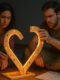 A couple sitting on the floor, assembling a glowing heart from IKEA-like parts, with a “How to Love” manual beside them, symbolizing miscommunication in relationships and the need to understand love languages.